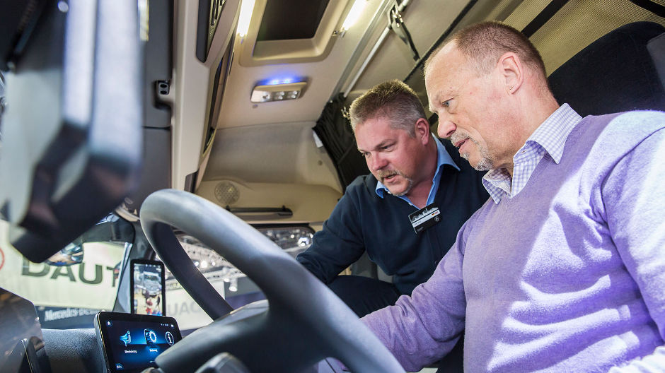Le chauffeur RoadStars Manfred Wandl (à droite) écoute attentivement les explications d'Olaf Broy sur les fonctions du Multimedia Cockpit.