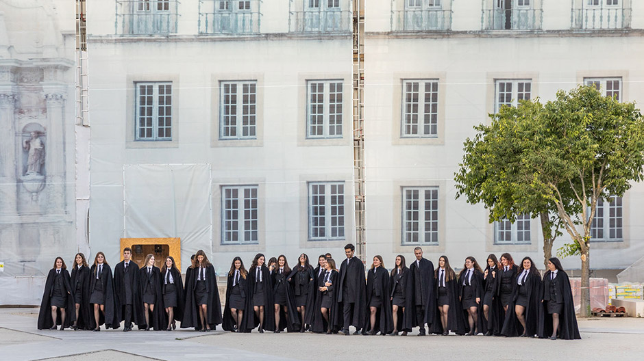 Black robes at the University of Coimbra with windmills in the hilly back country.