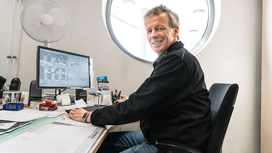 La computer. Michael Schneider de la Autohaus Rosier are acces în permanență la datele actuale ale autovehiculelor flotei – și astfel poate programa revizii, de exemplu.